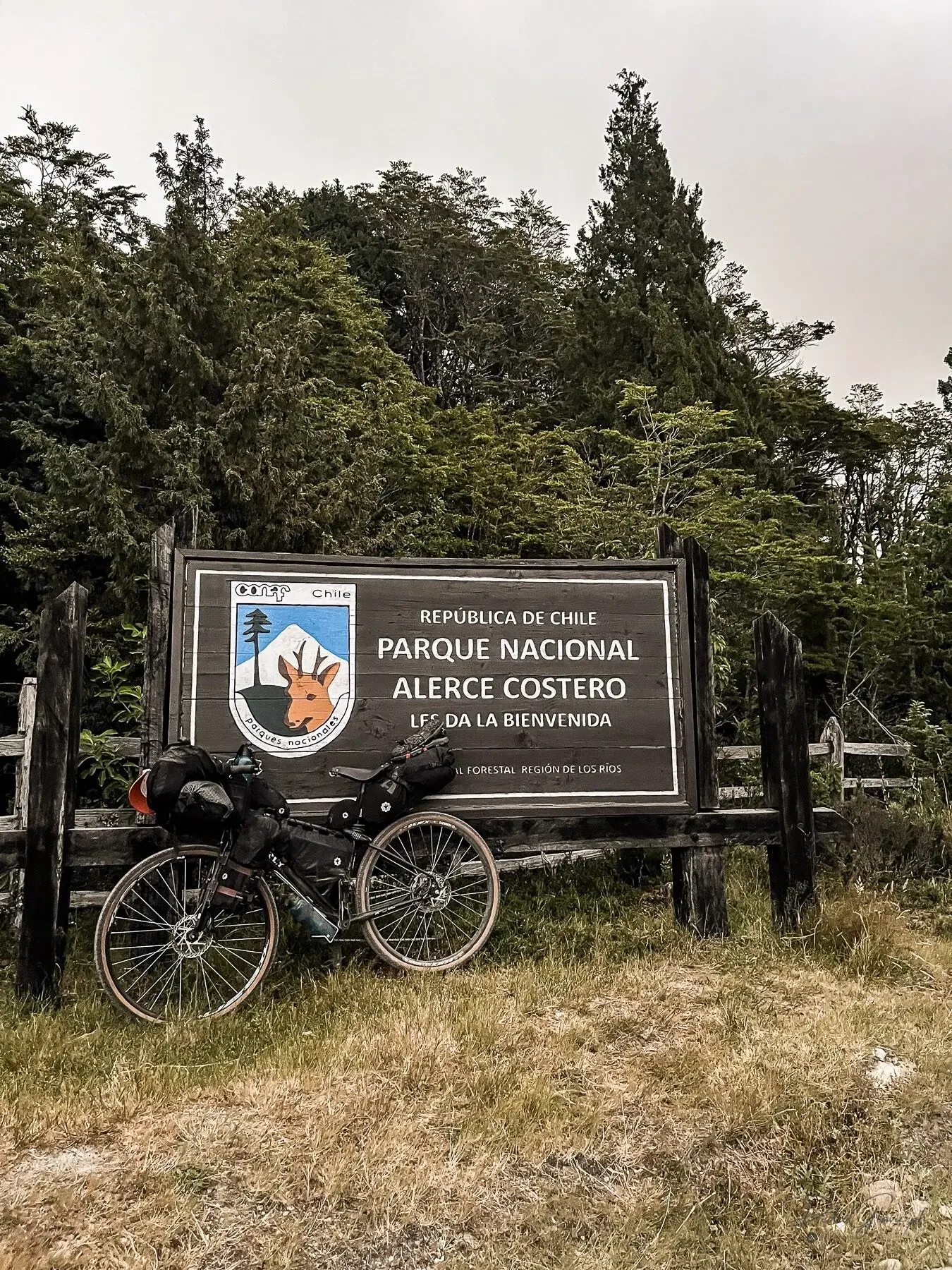 Bicicleta junto al letrero del Parque Nacional Alerce Costero